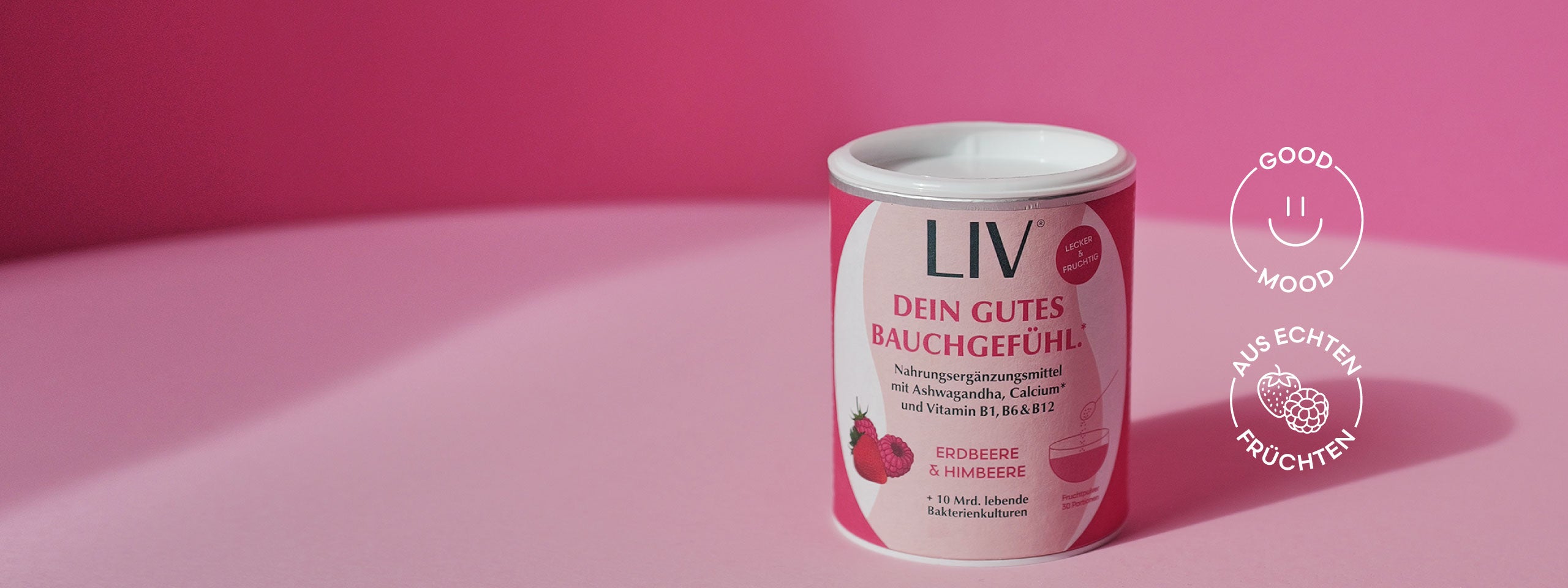 Verpackung der Darmkur vor einem rosa Hintergrund, neben einer visuellen Darstellung von einem Smiley mit der Aufschrift "Good Mood" und eine visuelle Darstellung von Erdbeere und Himbeere mit der Aufschrift "Aus echten Früchten".
